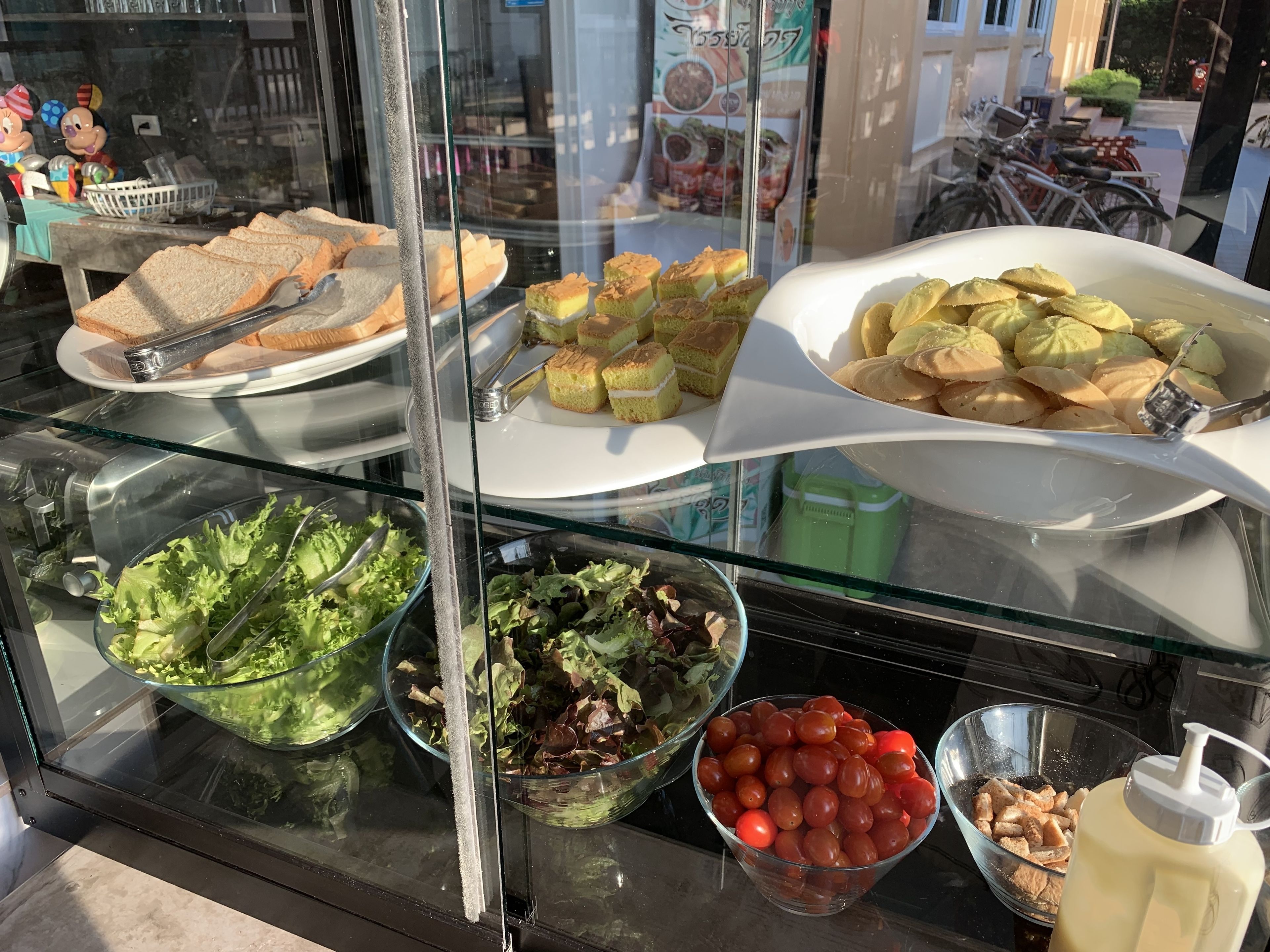 A buffet with various food items including salads, sandwiches, and desserts.