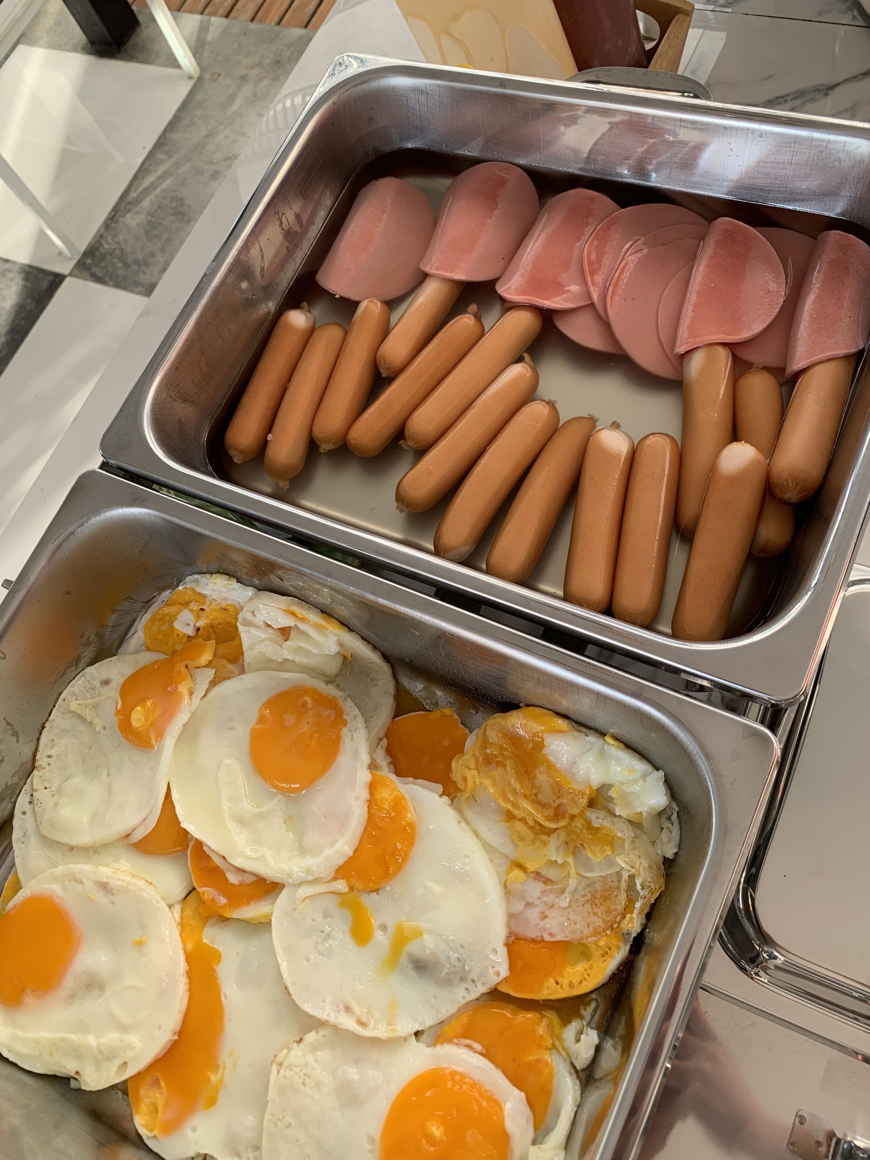 Un buffet proposant des hot-dogs et des œufs au plat.