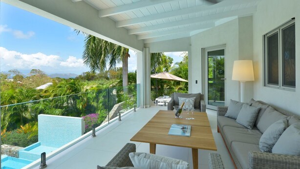 A modern outdoor living area with a pool, a wooden table, and a sofa. - Family Luxury, Resort Level Amenities, Ocean Views, Perfect Location, Gym. (Jessups)