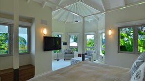 A spacious bedroom with a large bed, a TV, and a seating area with a sofa and armchairs. - Family Luxury, Resort Level Amenities, Ocean Views, Perfect Location, Gym. (Jessups)