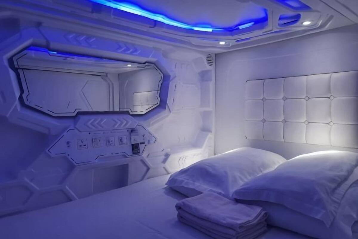 Ett sovrum med en våningssäng, en kontrollpanel och en futuristisk design.