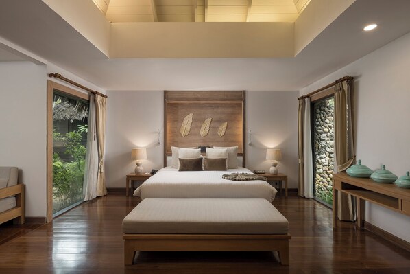 A bedroom with a large bed, bedside tables, a wooden headboard, and a view of greenery through the windows. - Khaolak Paradise Resort (Takua Pa)