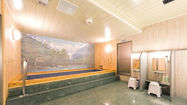 Un cuarto de sauna con pared de mosaico, bancos de madera y piso de baldosas.