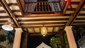 A traditional wooden structure with a balcony, hanging lanterns, and a wooden door. - Garden Yard Inn Chiangmai (Chiang Mai)