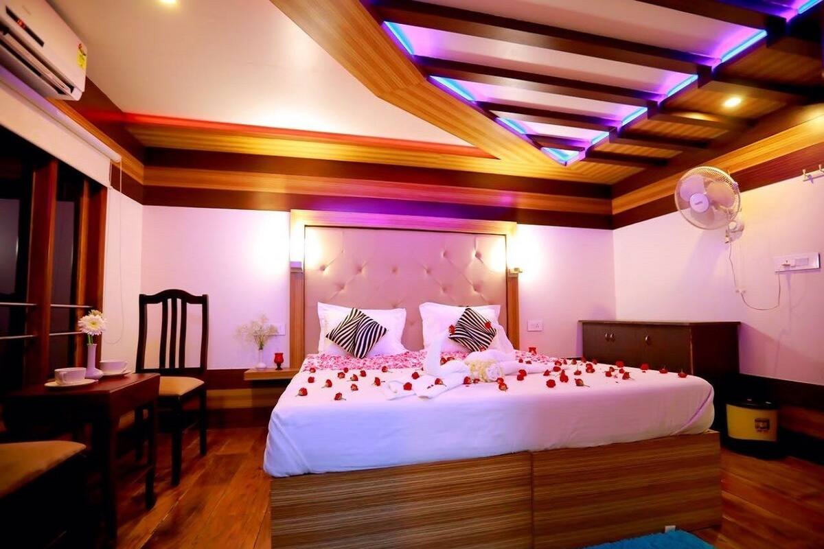 Une chambre à coucher avec un grand lit, une tête de lit en bois, des tables de chevet, un bureau et une chaise.