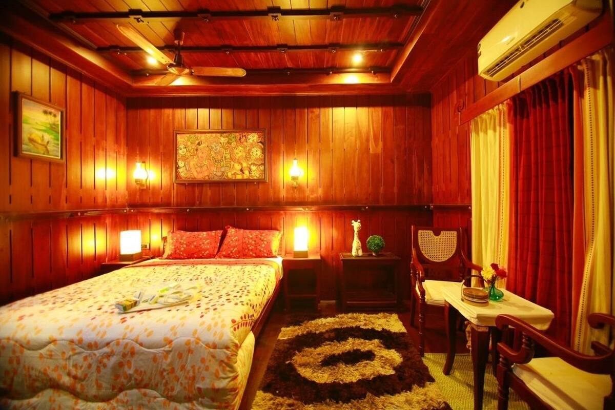 Une chambre à coucher décorée dans un style rustique, avec un lit, des tables de chevet, une table et des chaises.