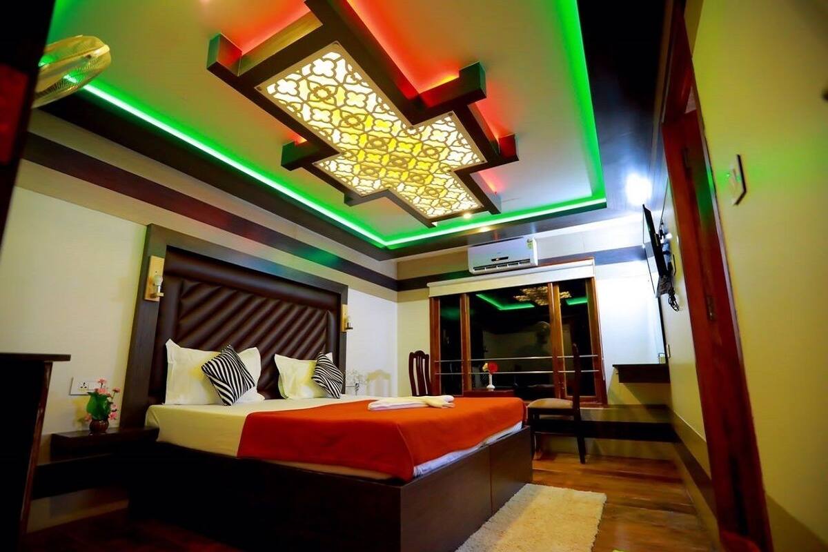 Une chambre moderne avec un grand lit, un plafond décoratif et une vue sur un balcon.