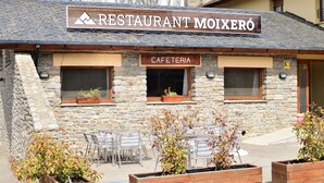 Un restaurante llamado Moixeró con terraza y paredes de piedra.