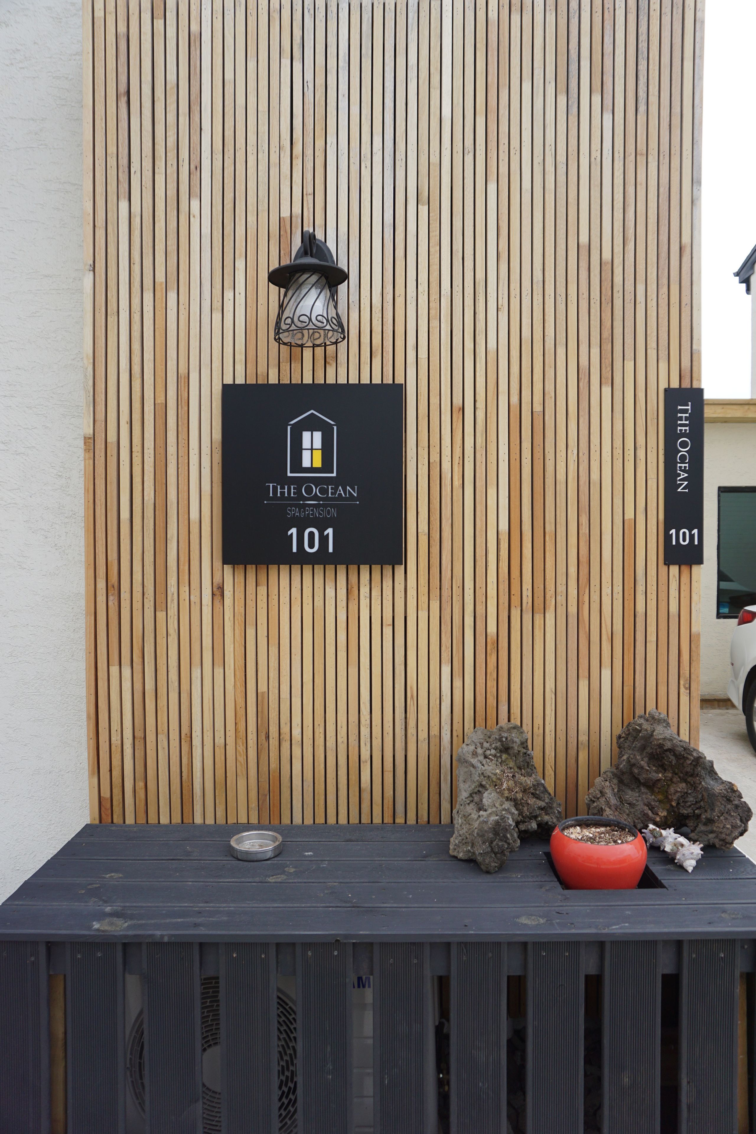 A wooden wall with a sign indicating "The Ocean Spa Pension 101".