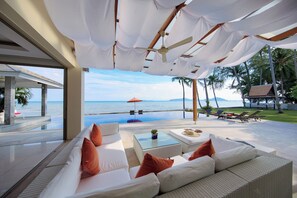 Een luxueus buitengebied met uitzicht op de oceaan, een zwembad en een overdekt terras.