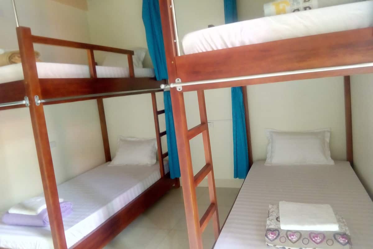 A bunk bed room with a lower bunk and a single bed. There is a ladder connecting the two beds.