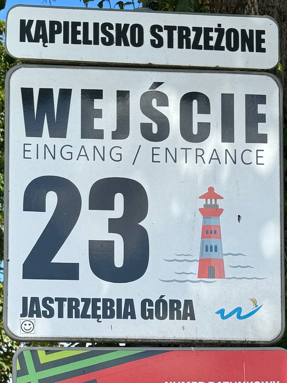 A sign with the number 23 and a lighthouse illustration, indicating Kapielisko Strzezone entrance.