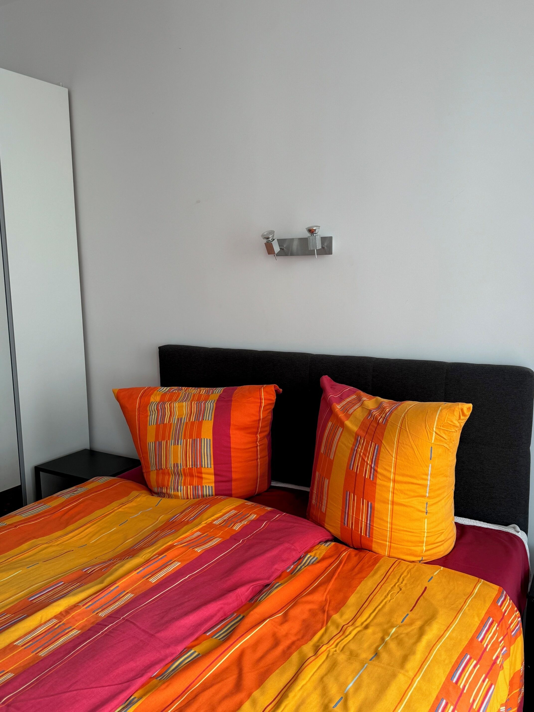 Una cama con dos almohadas y una colcha a rayas.