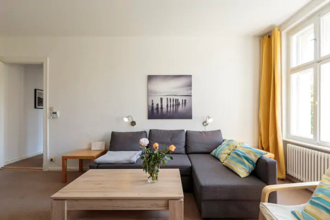 Een moderne woonkamer met een bank, een salontafel en een schilderij aan de muur.