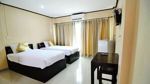 Habitación de hotel con dos camas, un escritorio y un televisor.