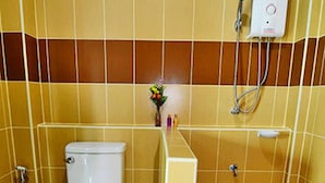 Un baño con inodoro, ducha y secamanos.