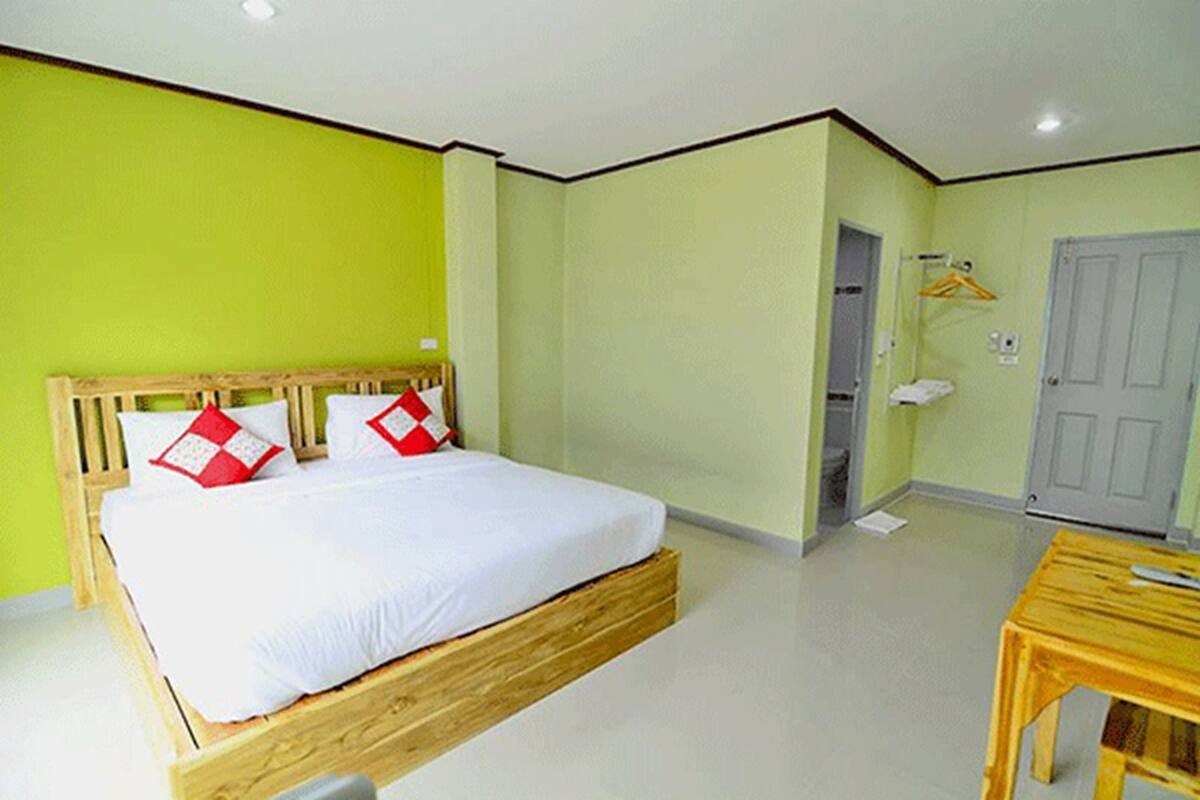 Um quarto com uma cama, uma mesa de madeira e uma porta.