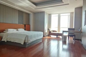Een moderne hotelkamer met een groot bed, een bureau en een stoel.