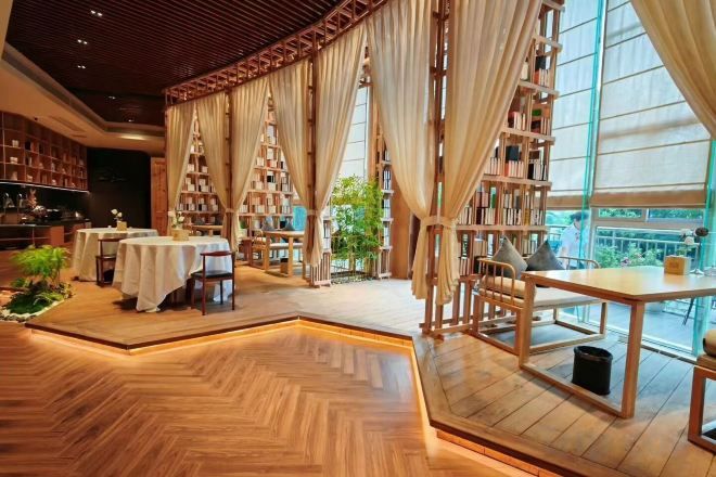 A library with bookshelves, tables, and chairs arranged for reading.