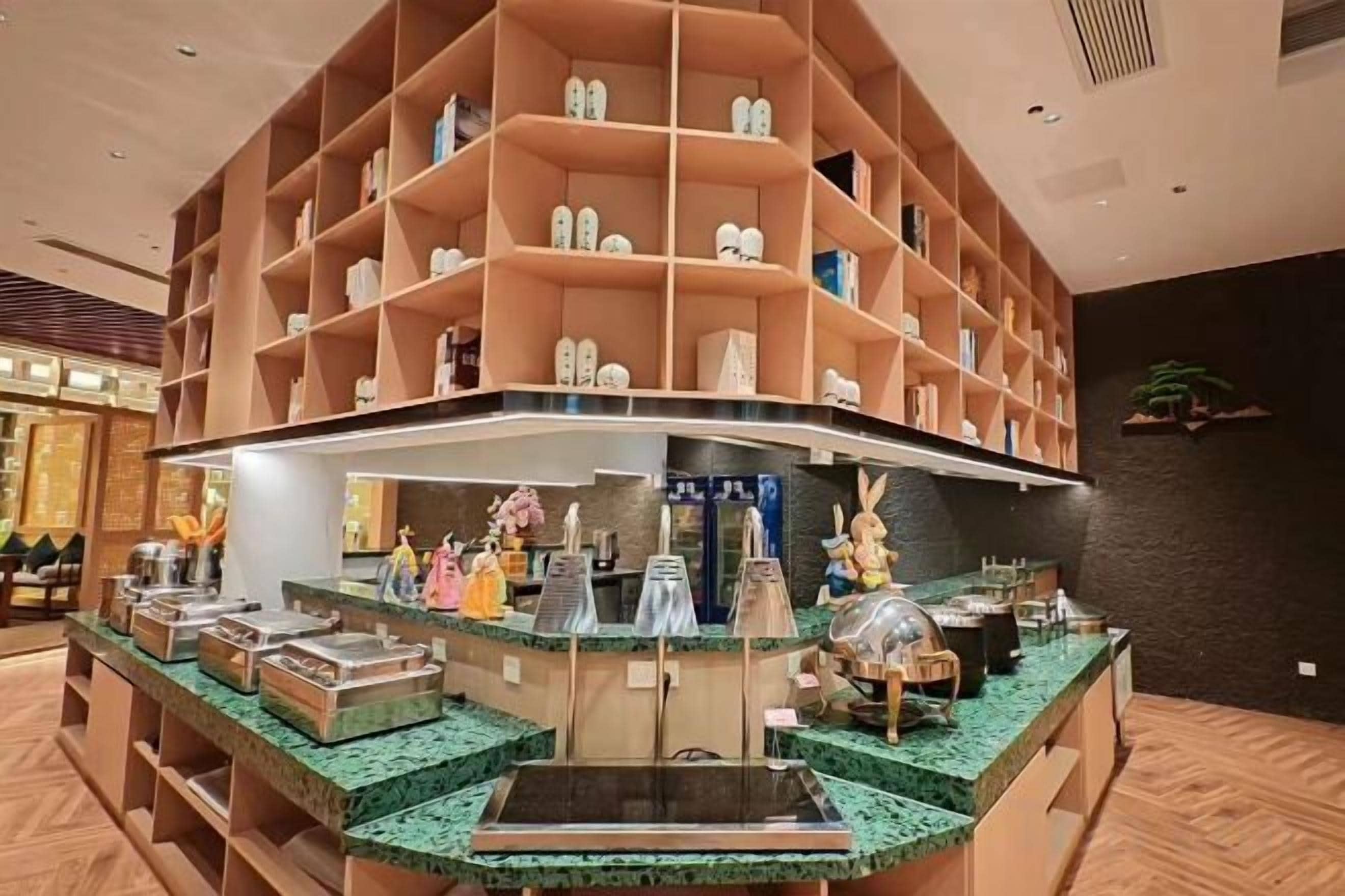 Un hall de hotel con mostrador central, varias exhibiciones de zapatos y una zona de recepción.