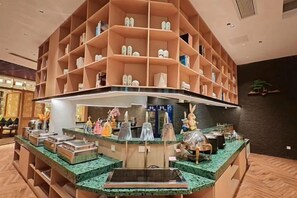 Een hotellobby met een centraal gelegen balie, verschillende schoonentoonstellingen en een receptiehoek.