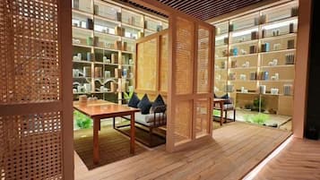 Una habitación con piso de madera, una mesa con sillas y una estantería llena de libros.