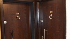 Dos puertas de madera oscura con manijas numeradas, que sugieren un sistema de acceso seguro.