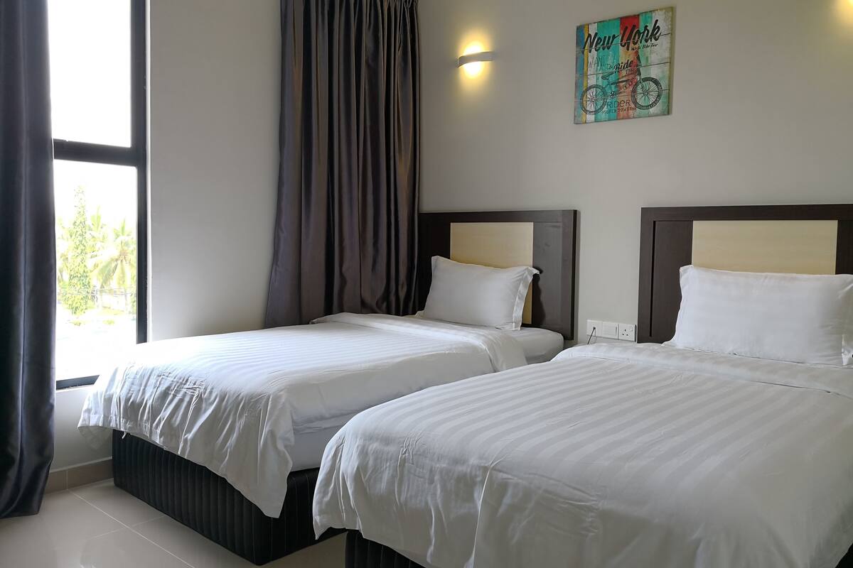 A hotel room with two beds, a large window, and a wall-mounted artwork.
