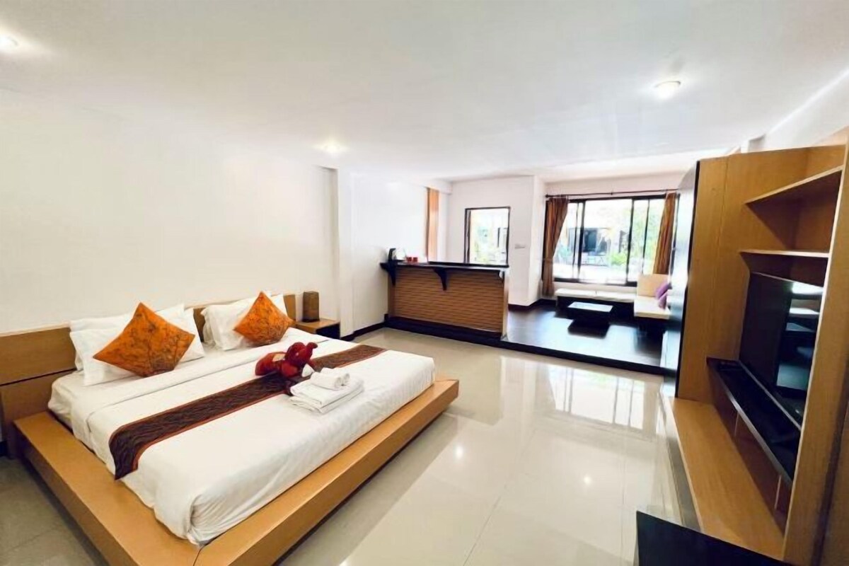Habitación de hotel moderna con una cama grande, televisión y vistas al exterior.