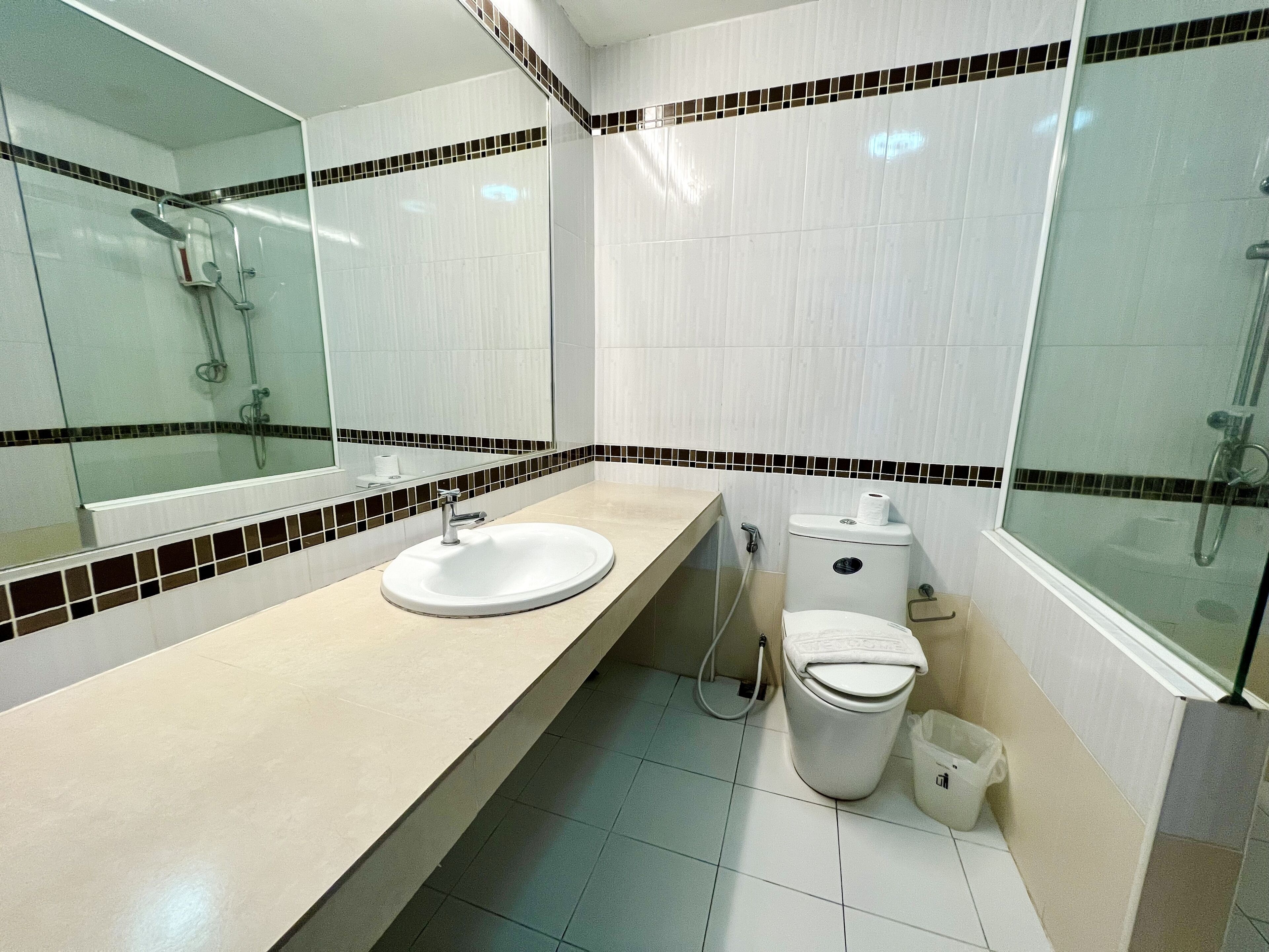 A modern bathroom with a sink, toilet, and shower.