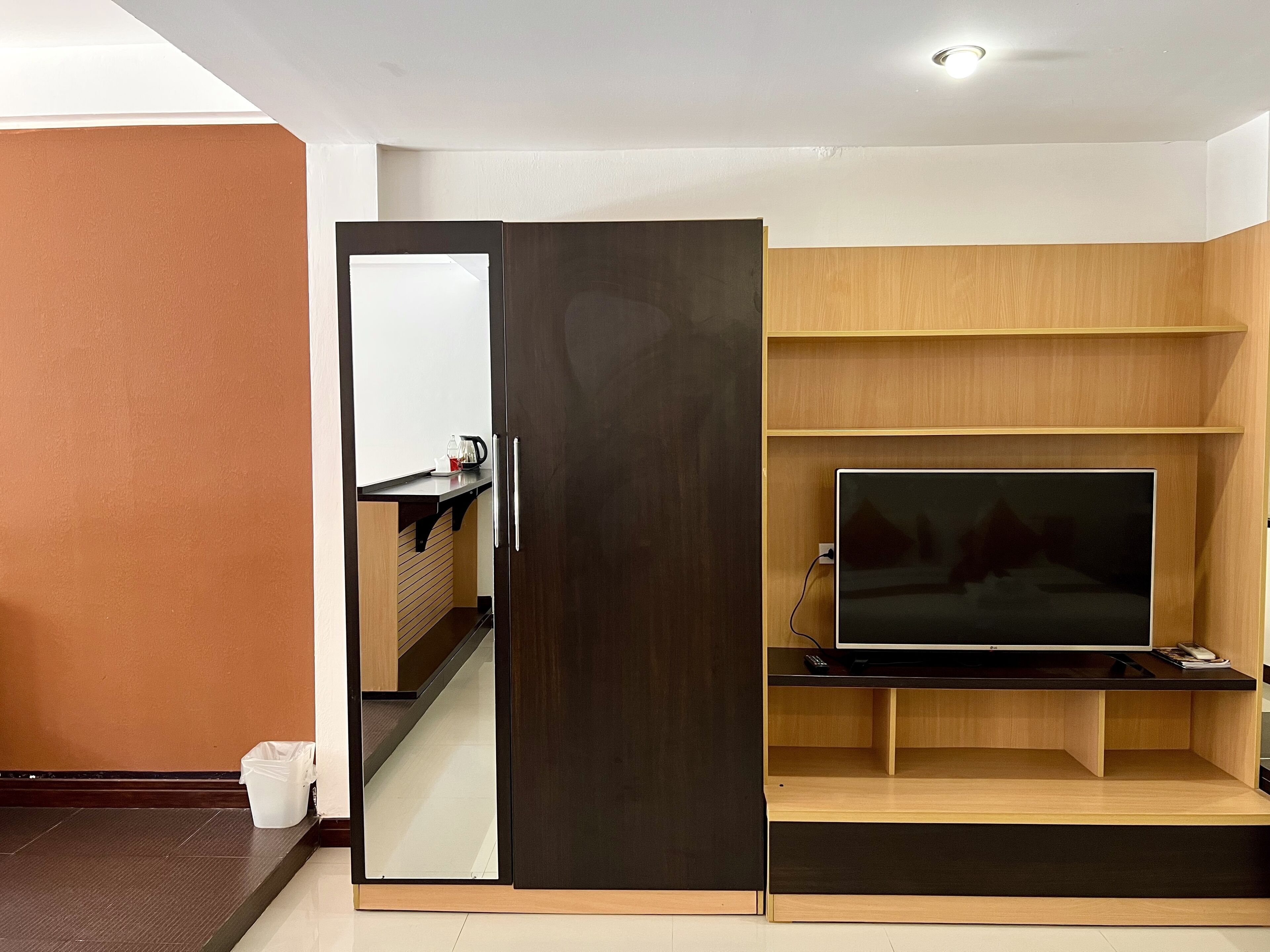 Un salon moderne avec un téléviseur, des étagères en bois et une porte coulissante.