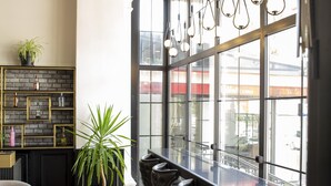A modern bar area with a wooden parquet floor, black and gold decor, and large windows offering a view of the city. - New Balturk Hotel Izmit (Izmit)