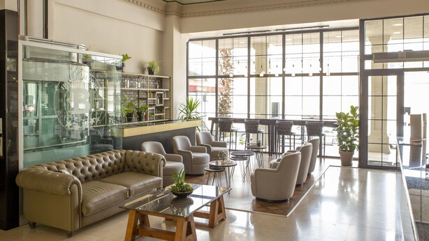 A spacious lobby with a leather sofa, multiple armchairs, a coffee table, and a glass display case. - New Balturk Hotel Izmit (Izmit)