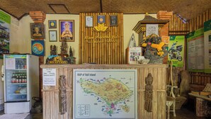 A reception desk with a map of Bali Island, framed by traditional Balinese decor and a sign for 'Alam Praceatha Bali'. - Alam Pracetha Bali (Ubud)