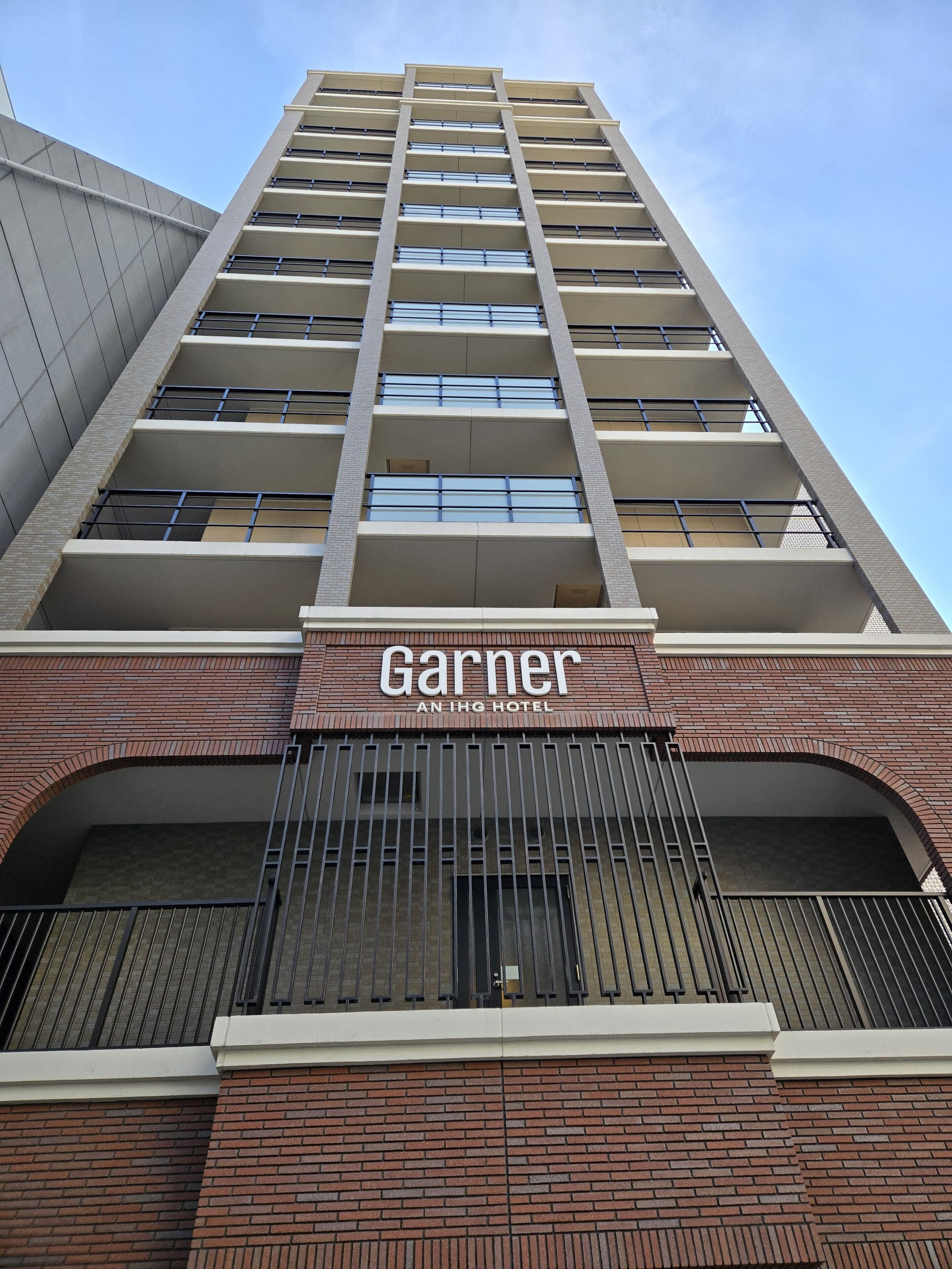 En hög hotellbyggnad med en väl synlig skylt där det står "Garnier, ett hotell i IHG-kedjan".