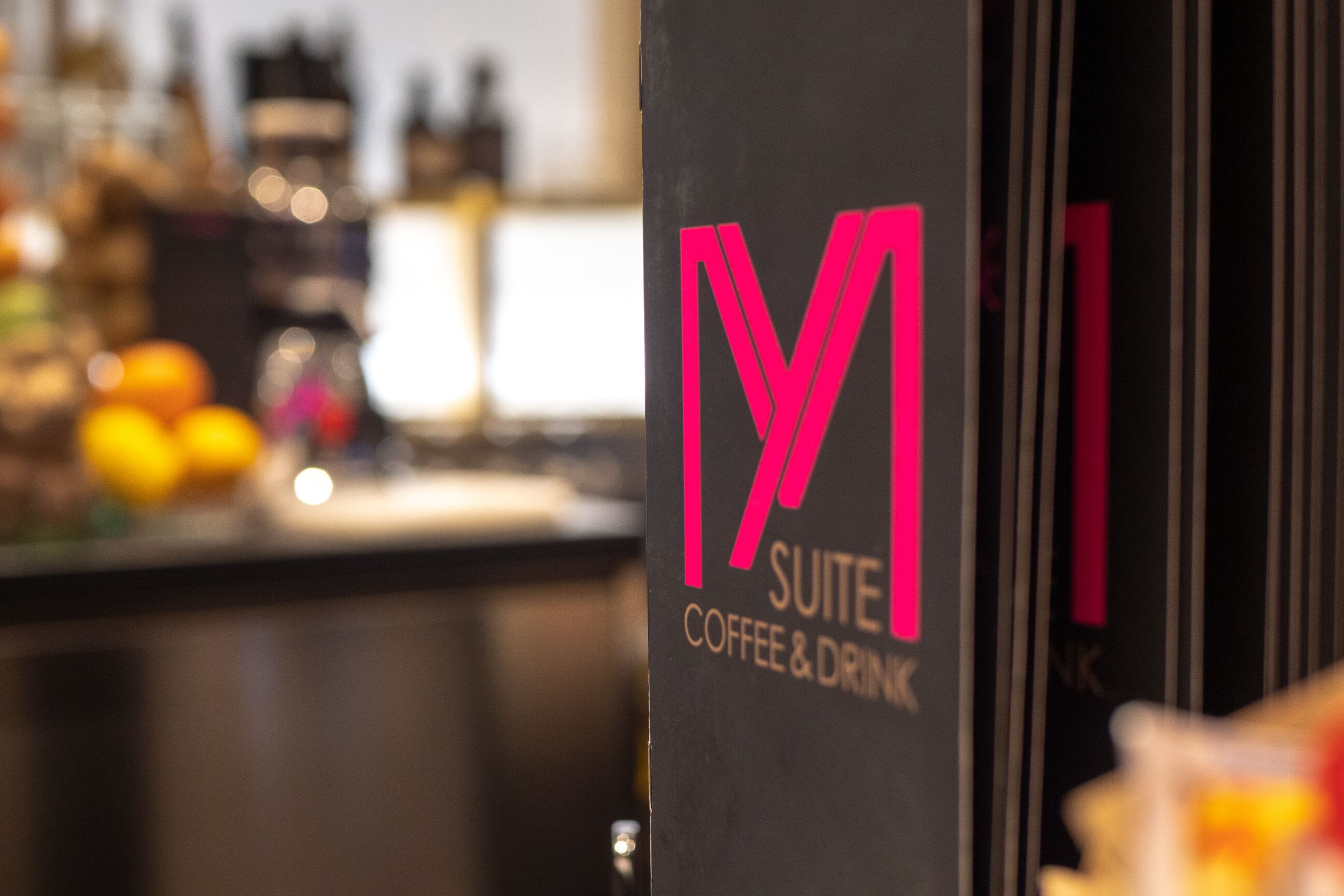 Une enseigne avec l’inscription « M SUITE COFFEE & DRINK ».