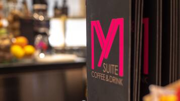 Une enseigne avec l’inscription « M SUITE COFFEE & DRINK ».