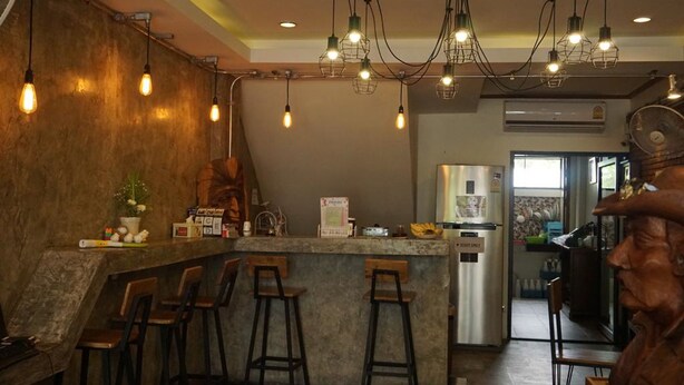 A bar area with a counter, stools, and hanging light fixtures. - T2B Home - Adults Only - Hostel (Chiang Mai)