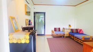 A compact living space with a bed, a small table, and a sofa. - T2B Home - Adults Only - Hostel (Chiang Mai)