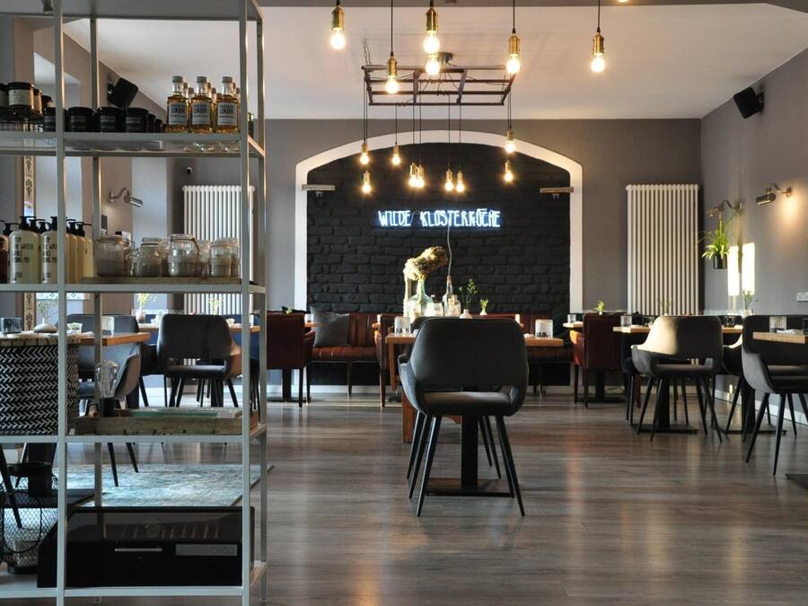 A modern interior with a central seating area, shelves with various items, and a neon sign on the wall.