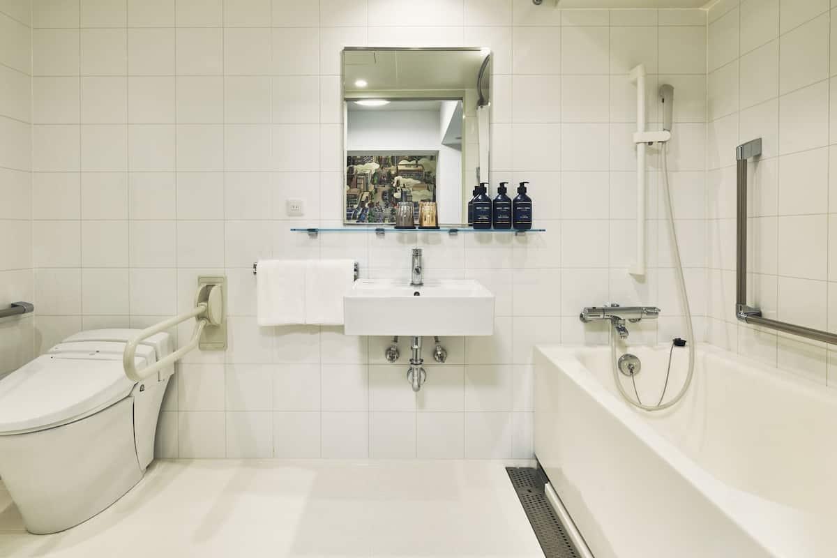Une salle de bain moderne équipée de toilettes, d’un lavabo et d’une baignoire.