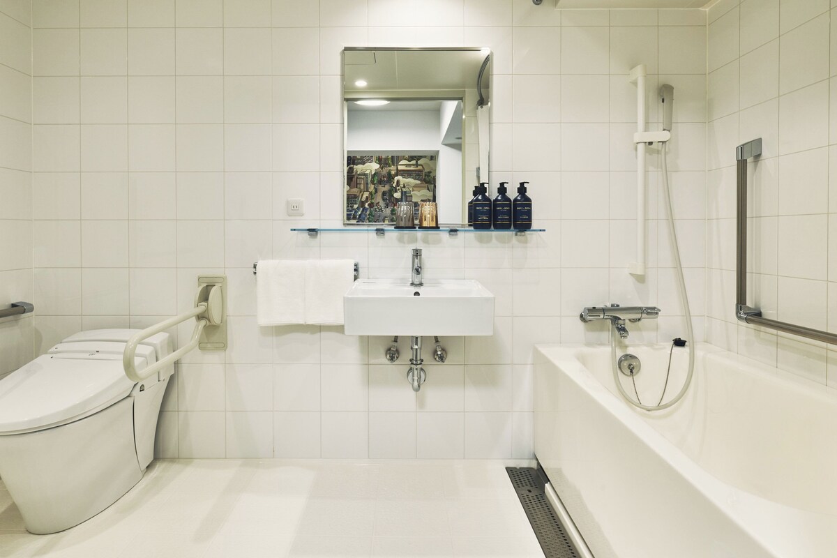 Een moderne badkamer met toilet, wastafel en bad.