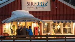 Un edifici vermell amb un cartell que diu "SIKEFORS konferens & fritidsby" i "INCHECKNING & RESTAURANG".