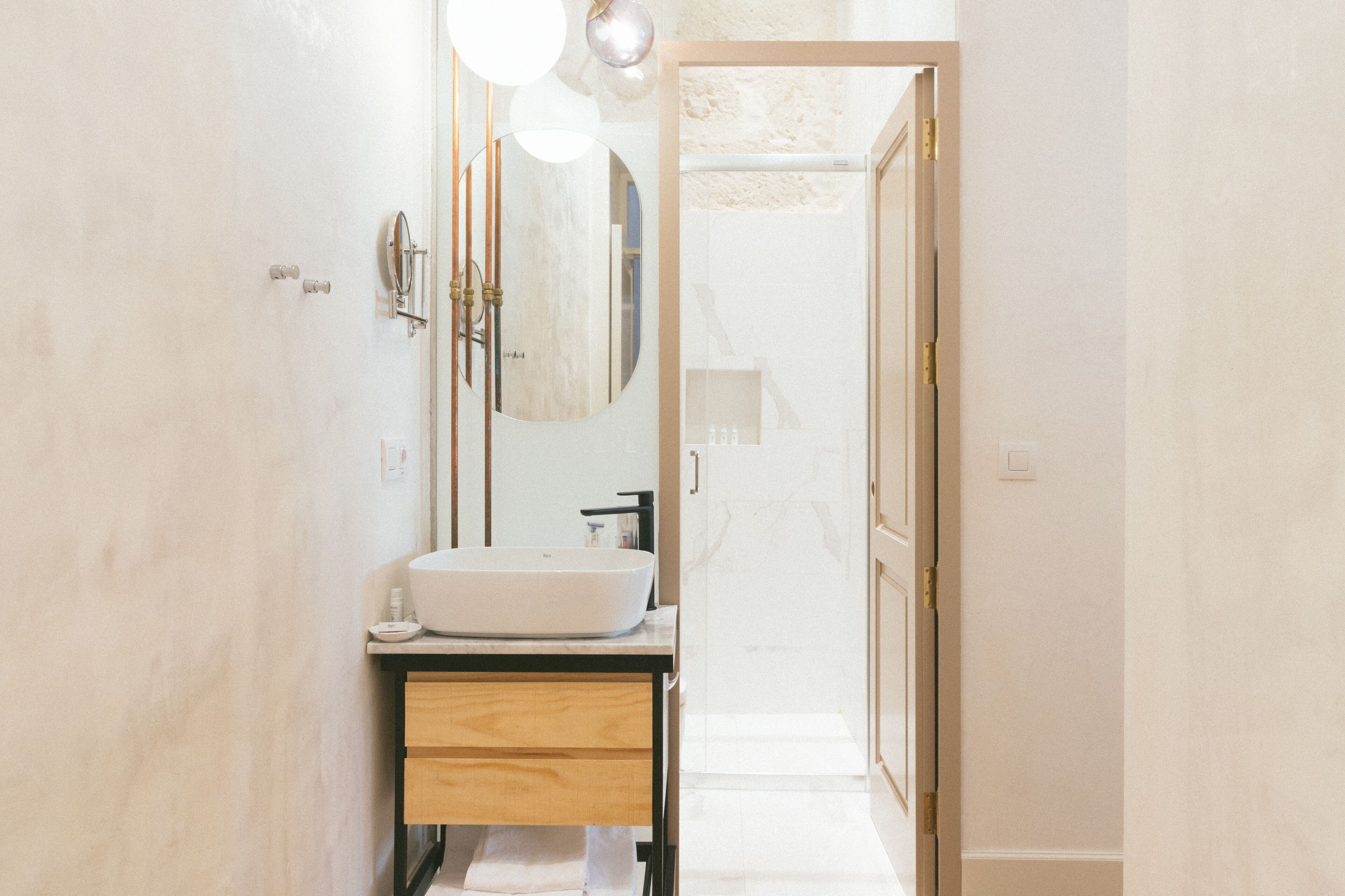 Un baño moderno con un lavamanos grande, un espejo y un perchero para toallas.