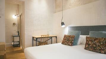 A bedroom with a large bed, a desk, and a chair.