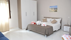 Un dormitorio con un armario amplio, una cama con almohadas y una mesita de noche.