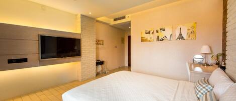 A modern hotel room with a large bed, a flat-screen TV mounted on the wall, and artwork depicting famous landmarks.