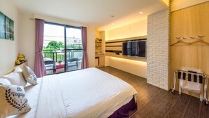 Una habitación de hotel moderna con una cama grande, televisión, kitchenette y balcón con vistas.