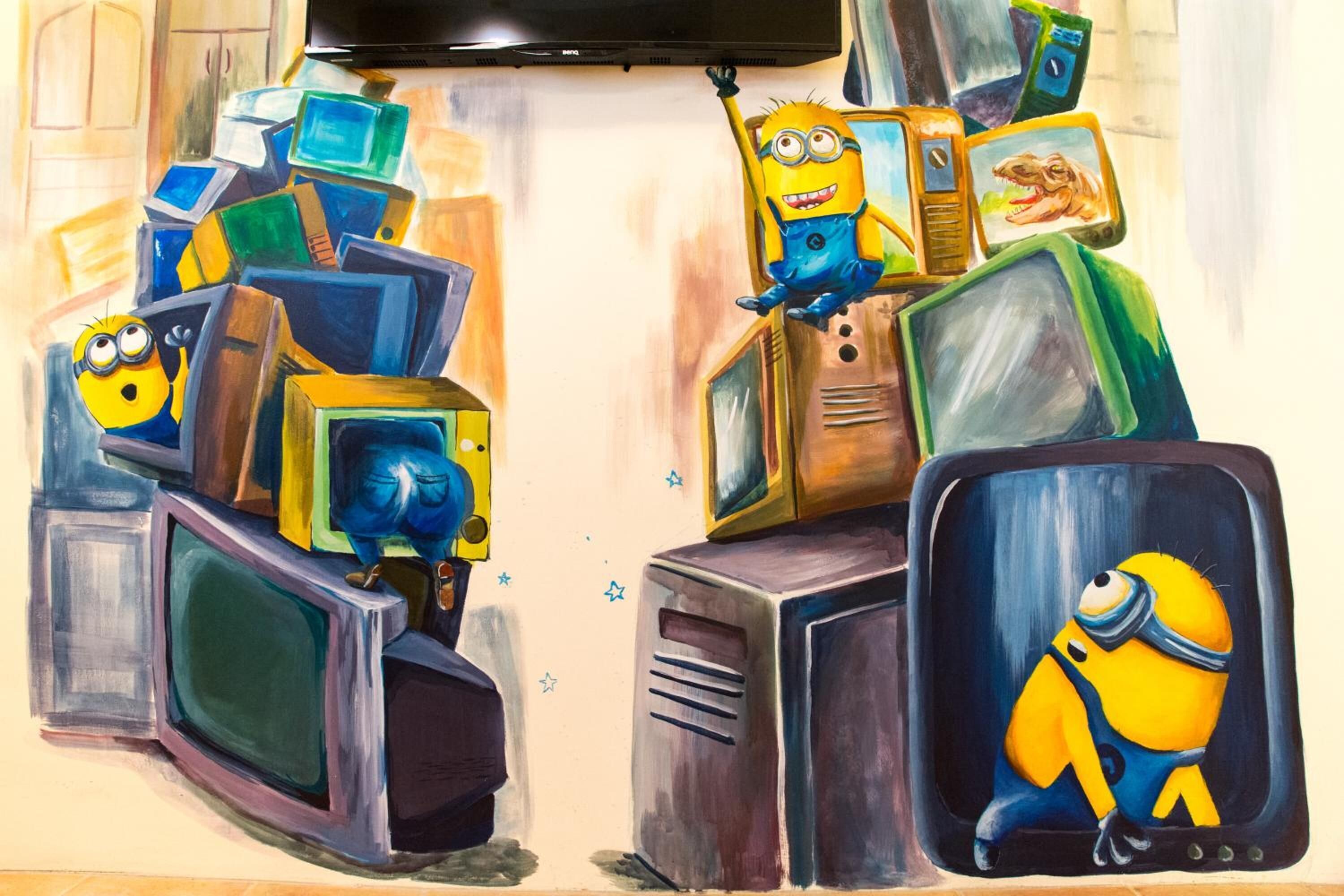 A room with a television on the wall and a Minion character on a TV screen.