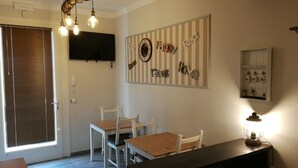 Un comedor con una mesa y sillas de madera, un reloj de pared y un estante con llaves.